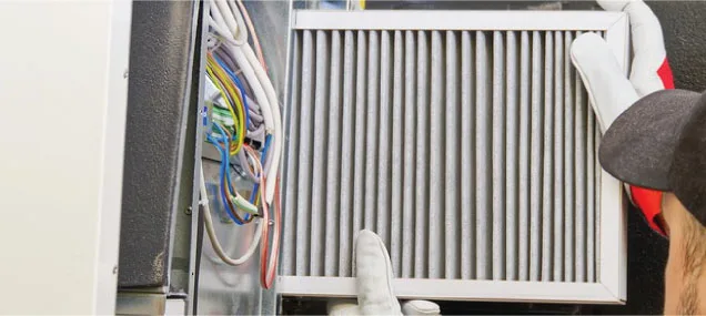 A Reliable Comfort Services technician installs a whole-home air filtration system in a Murfreesboro home's HVAC unit.