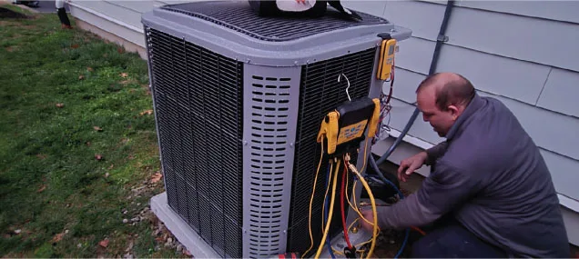 A Reliable Comfort Services technician services an outdoor air conditioning condenser unit at a Middle Tennessee home