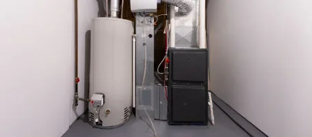 A dependable gas furnace stands next to the water heater in a clean, well-kept home utility closet, ready for the cold Tennessee nights.